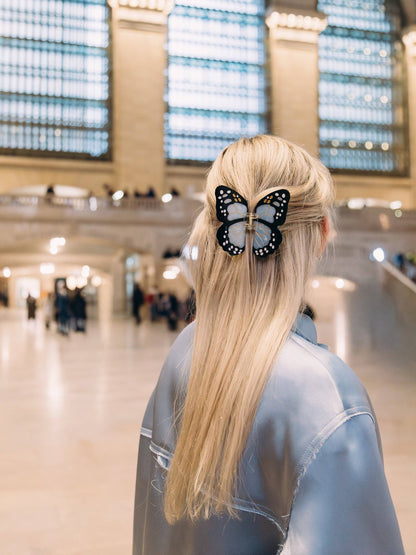 Blue butterfly clip in long blonde hair in a grand station hall