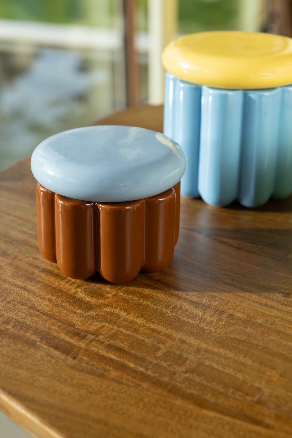 Brown and blue Charlo jars on a wooden table