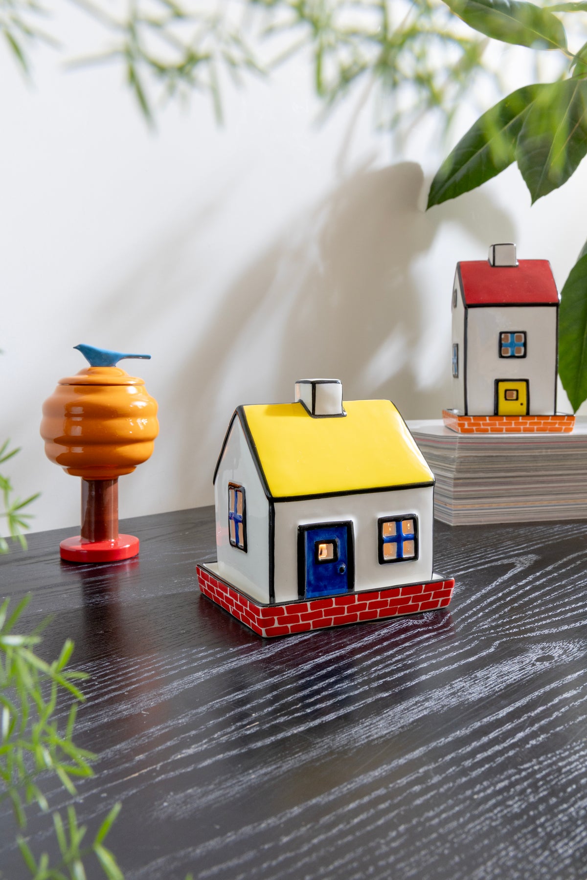 Tealight cottage on a dark wooden table beside other small decorative houses
