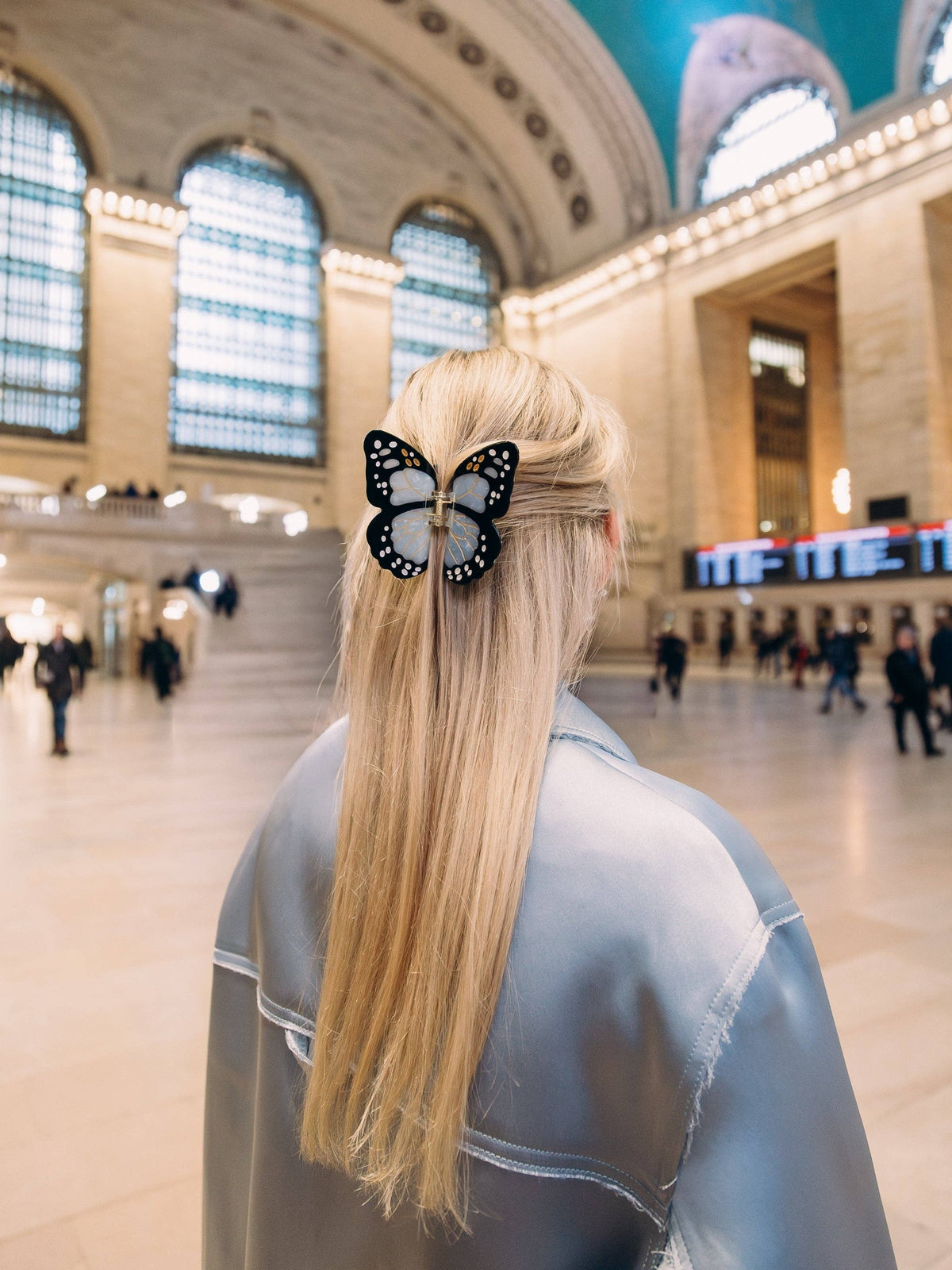 Butterfly claw clip in long blonde hair in a station