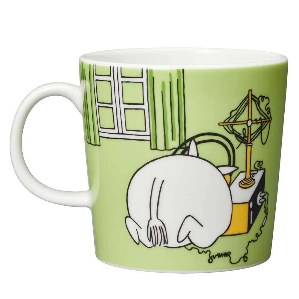 Other side of the grass green mug: Moomintroll crouching beside a house with a pan