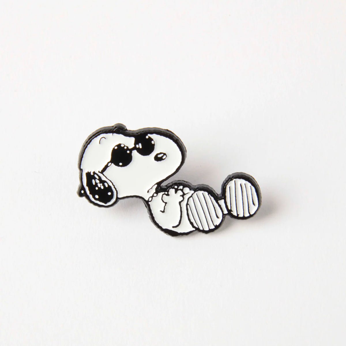 Enamel pin of Snoopy lounging in sunglasses