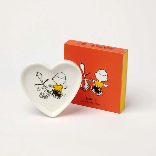 Heart-shaped Peanuts trinket dish with Charlie Brown dancing with Snoopy, beside its orange box