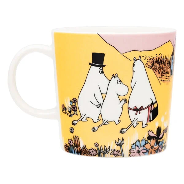 Other side of the Family Time mug: the Moomin family walking through flowers