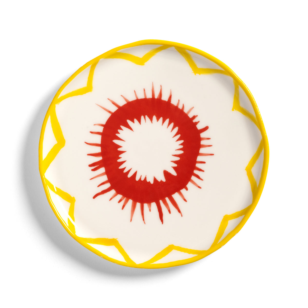 &K Festivo small plate in white with a red burst and yellow zigzag rim