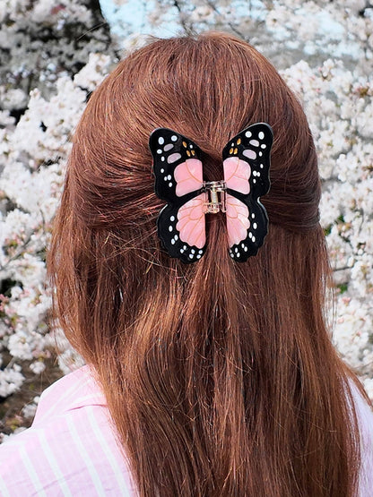 Close-up of the pink butterfly clip holding back auburn hair