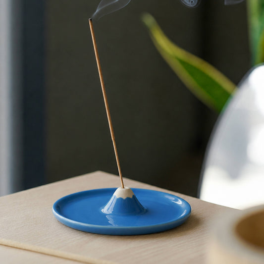 Blue ceramic Mount Fuji incense burner with a burning stick