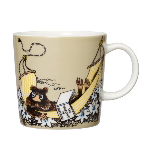 Beige Moomin mug with the Muskrat reading in a hammock