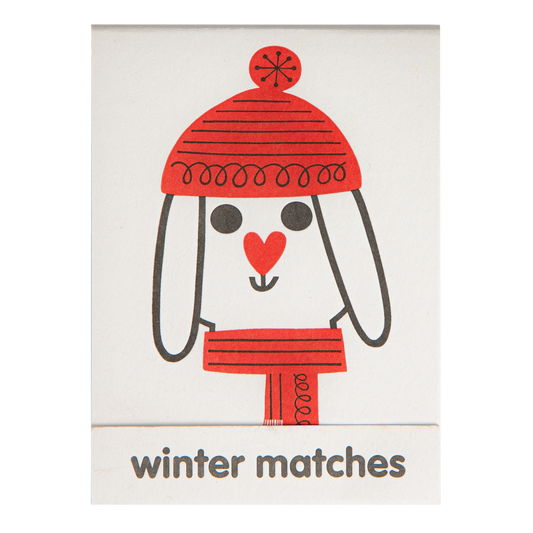 Match book cover: a dog in a red bobble hat and scarf: Winter matches