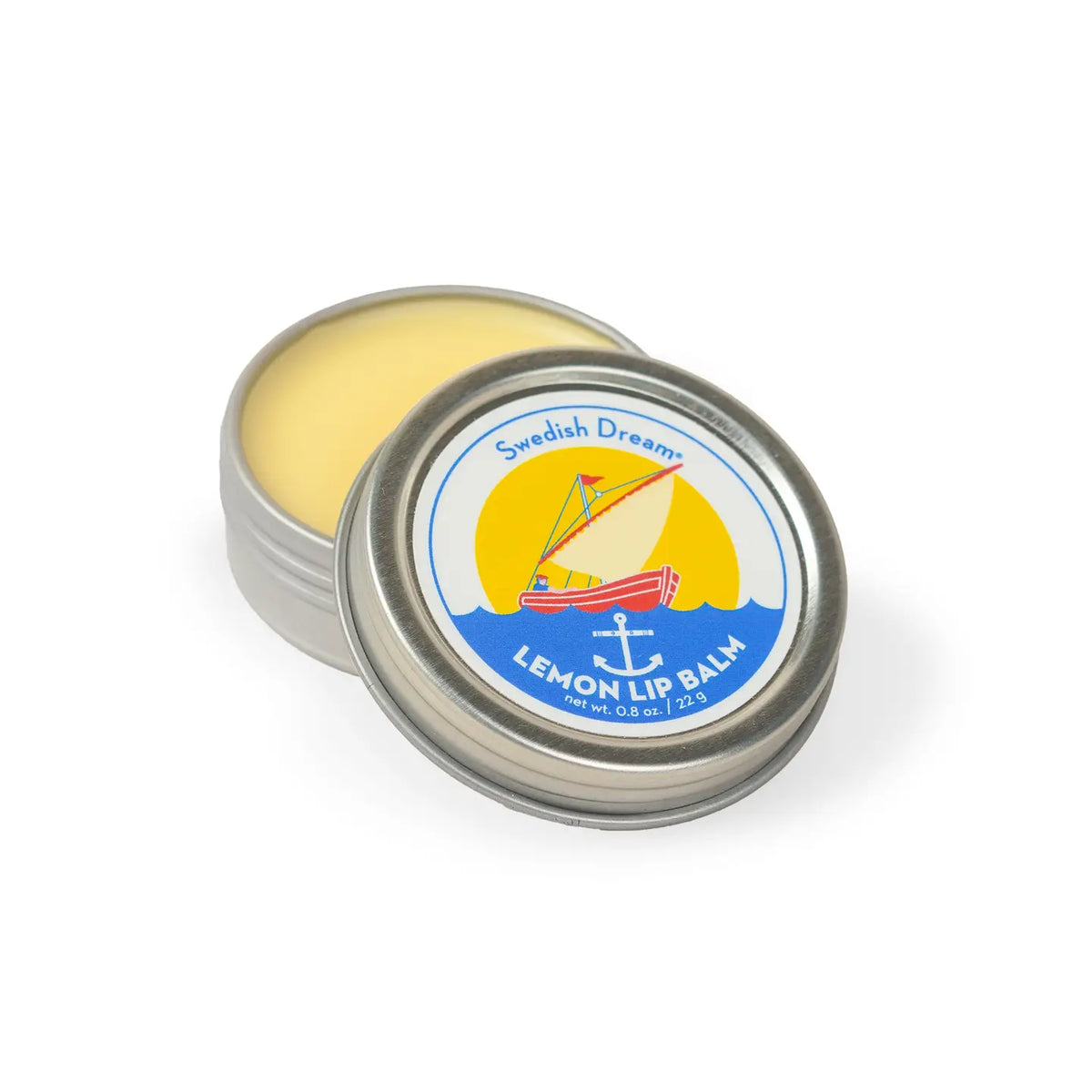 Swedish Dream lemon lip balm: an open round tin showing the yellow balm, with a sailing boat on the lid
