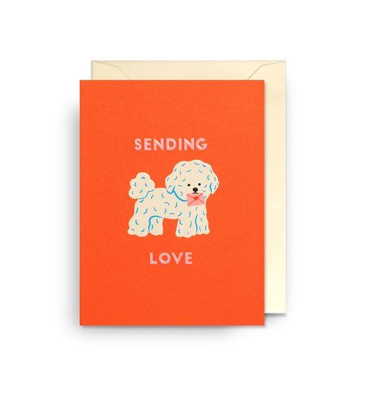 Lagom mini card: a fluffy white dog with a pink bow on red-orange, with 'Sending love'