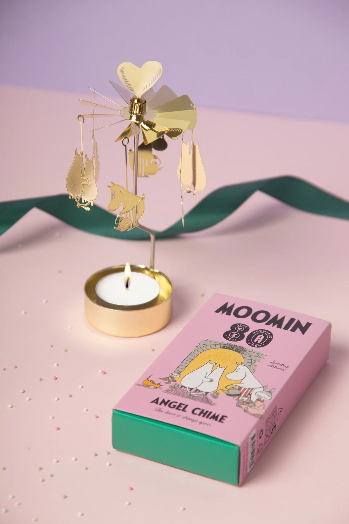 Gold Moomin 80 angel chime with a lit tealight beside its box