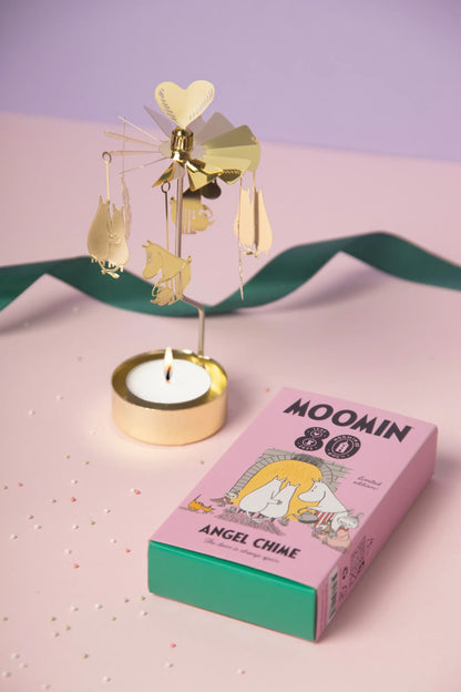 Gold Moomin 80 angel chime with a lit tealight beside its box