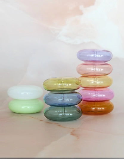 Stacks of Botanica glass incense holders in green, blue, yellow, pink, purple and amber