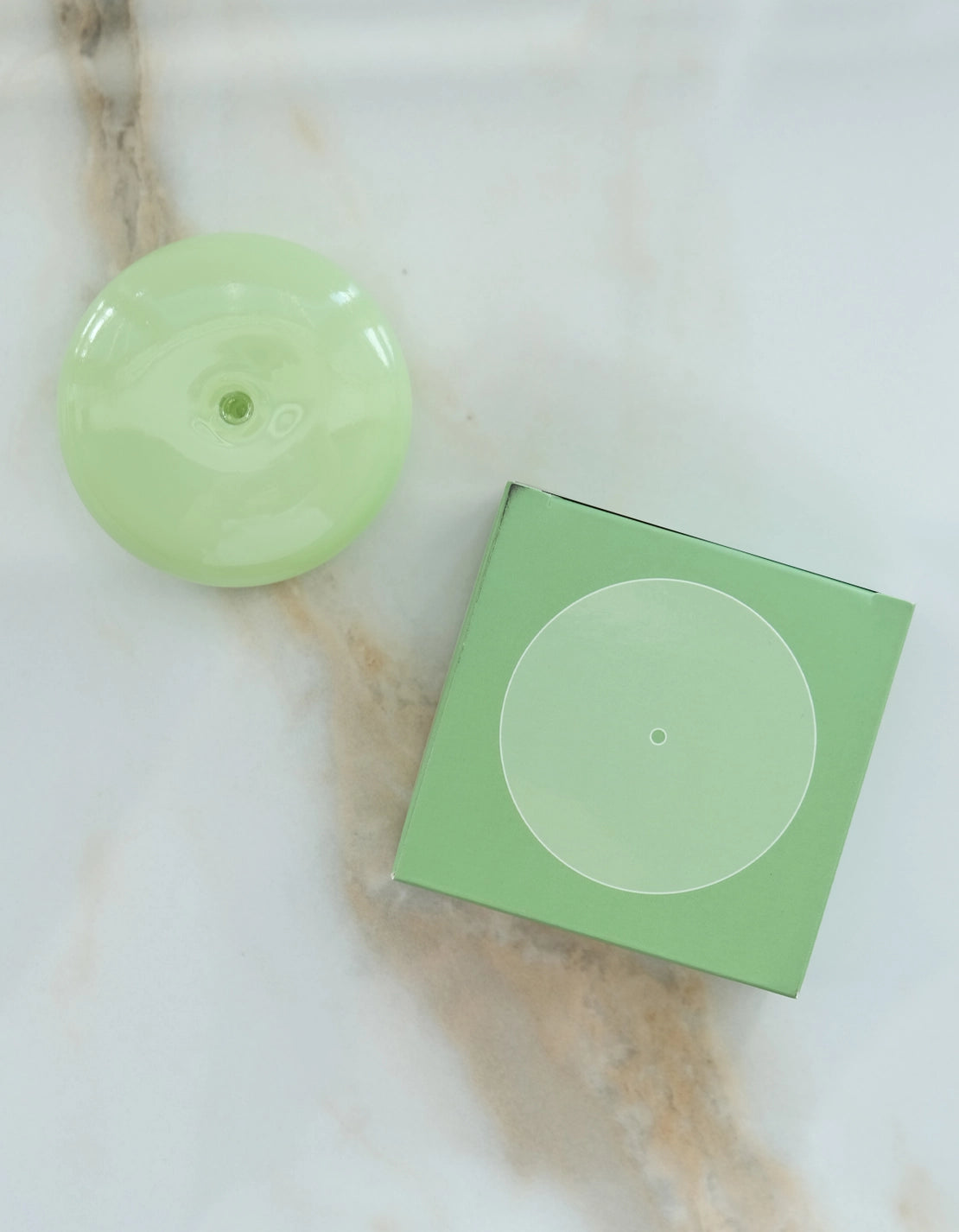 Botanica jade milk incense holder: a pale green glass disc beside its green box