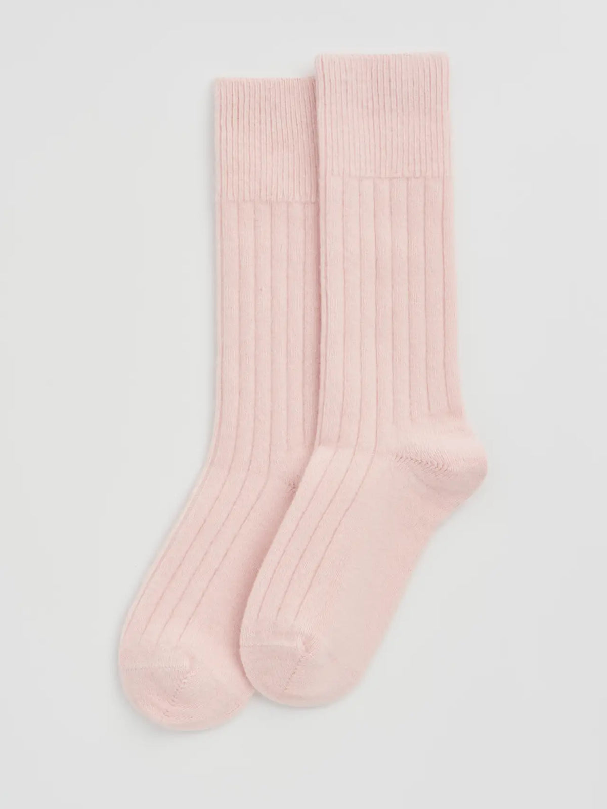 Pair of frosting pink ribbed bed socks laid flat