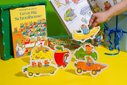 Hand holding up the Core Memory die-cut card among Richard Scarry car cards and books