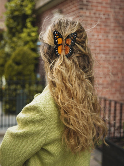 Orange butterfly clip in curly blonde hair
