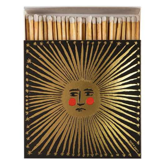 Archivist Sun matches: a black box with a gold sunburst face with rosy cheeks, slid open to show the matches