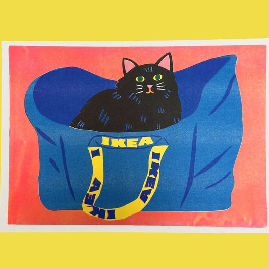 Naomi Wilkinson A3 riso print: a black cat sitting in a blue IKEA bag on coral