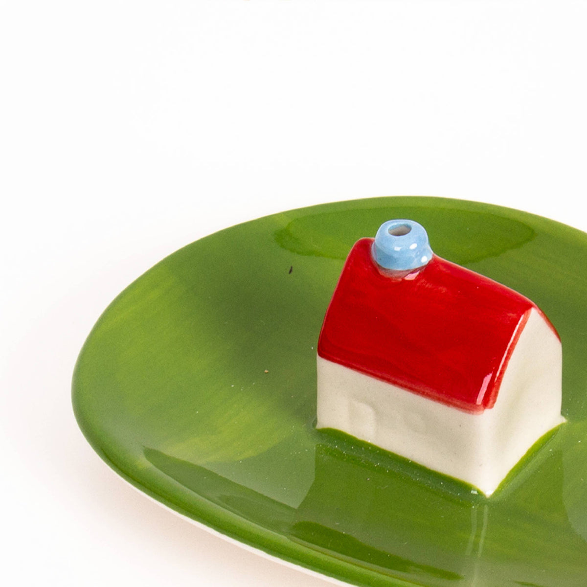 Close-up of the little house on the green incense dish