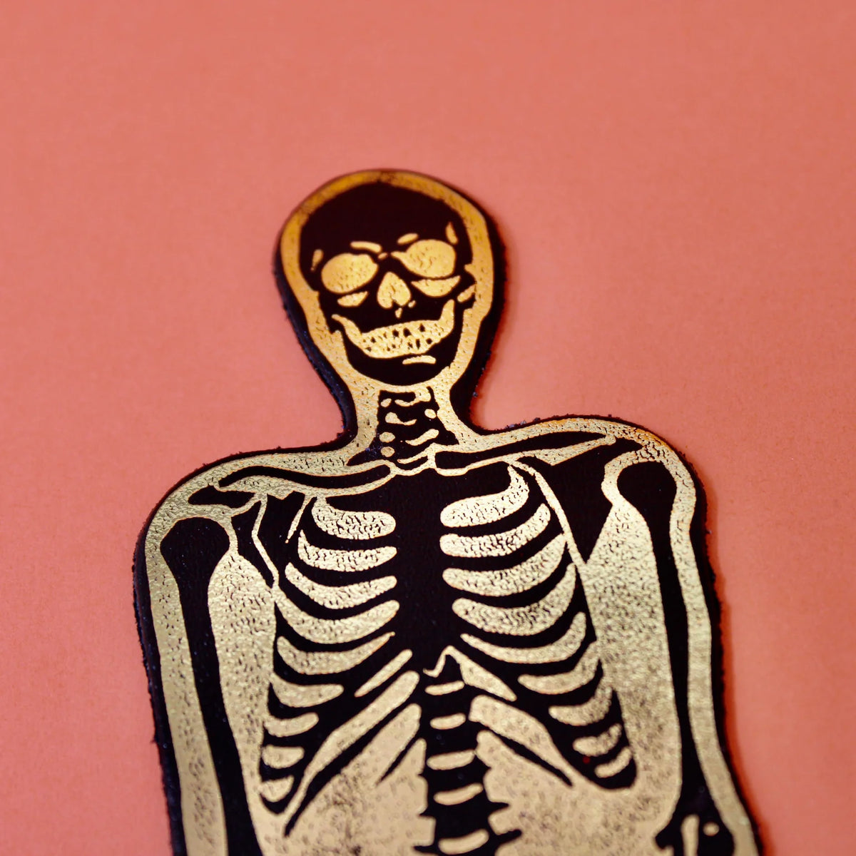 Ark skeleton bookmark in black and gold, close-up