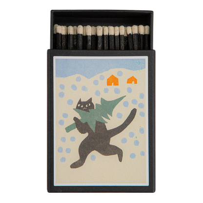 Keepsake matchbox with a cat carrying a Christmas tree in the snow