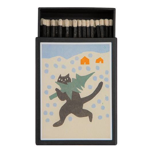 Keepsake matchbox with a cat carrying a Christmas tree in the snow