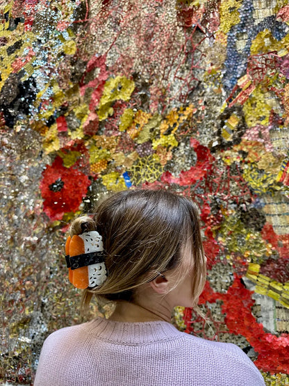 Woman wearing the sushi clip in front of a colourful wall