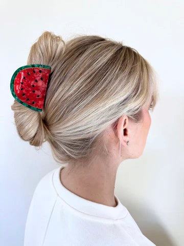 Watermelon claw clip holding up blonde hair