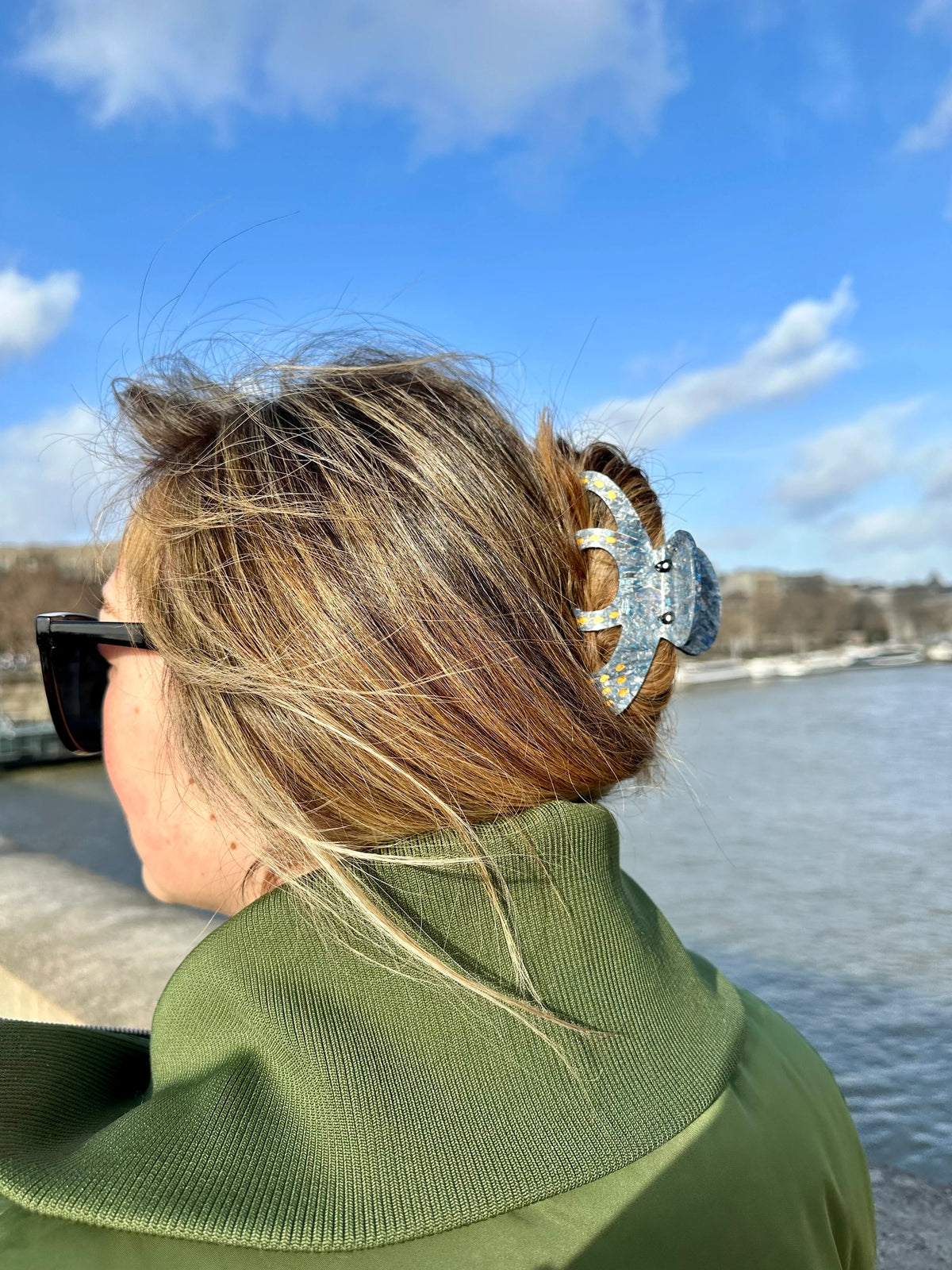 Woman by the water wearing the blue octopus hair clip