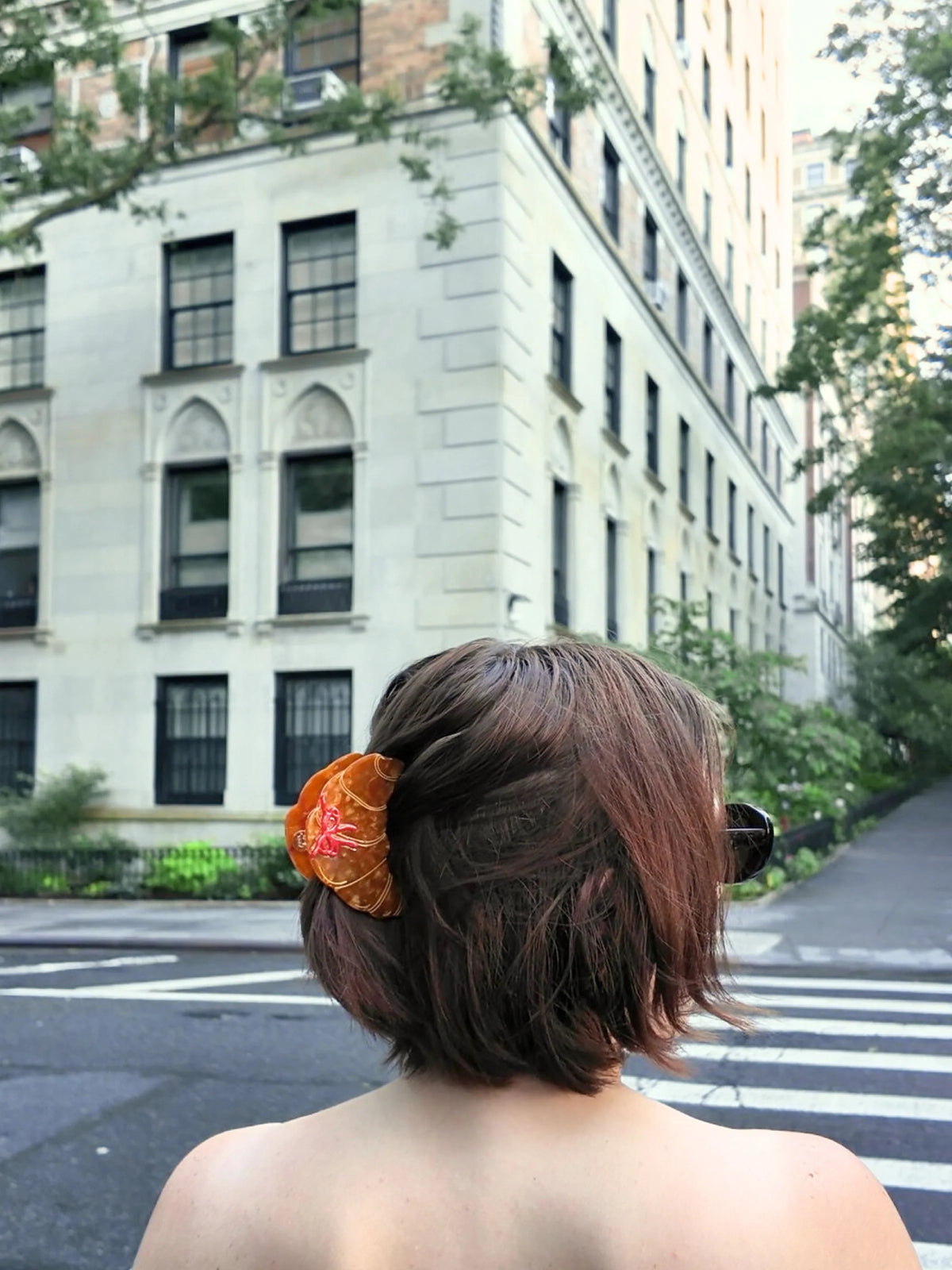 Croissant claw clip in a brown bob on a city street