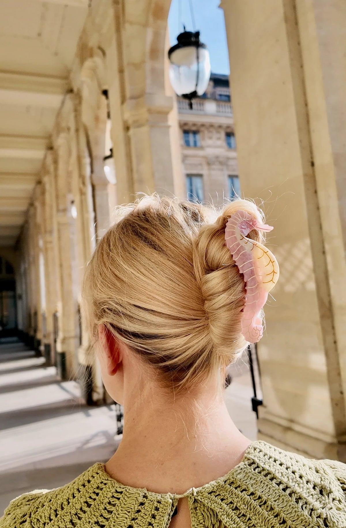 Woman wearing the pink seahorse clip in a blonde twist