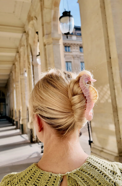Woman wearing the pink seahorse clip in a blonde twist
