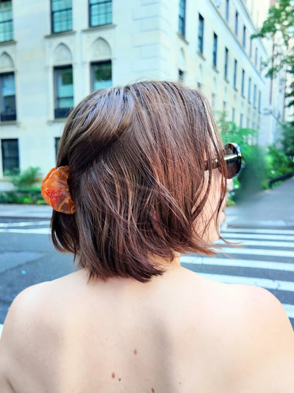 Mini croissant claw clip in a brown bob on a city street