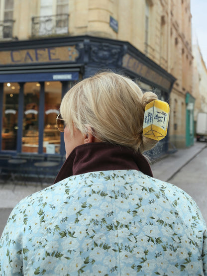 French butter claw clip in blonde hair outside a café