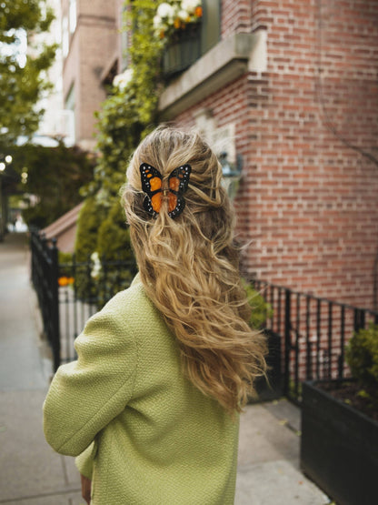Orange butterfly clip in curly hair on a street
