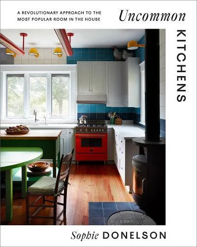 Uncommon Kitchens by Sophie Donelson: cover photo of a colourful kitchen with blue tiles and a red range cooker