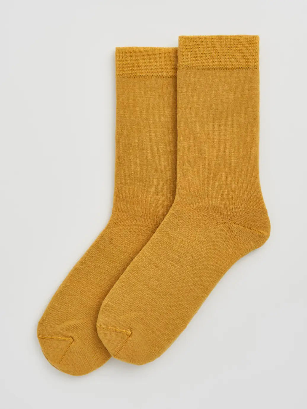 Pair of golden yellow calf-length merino socks laid flat