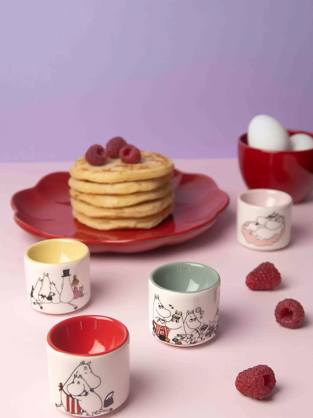 Moomin Love egg cups on a table with pancakes and raspberries