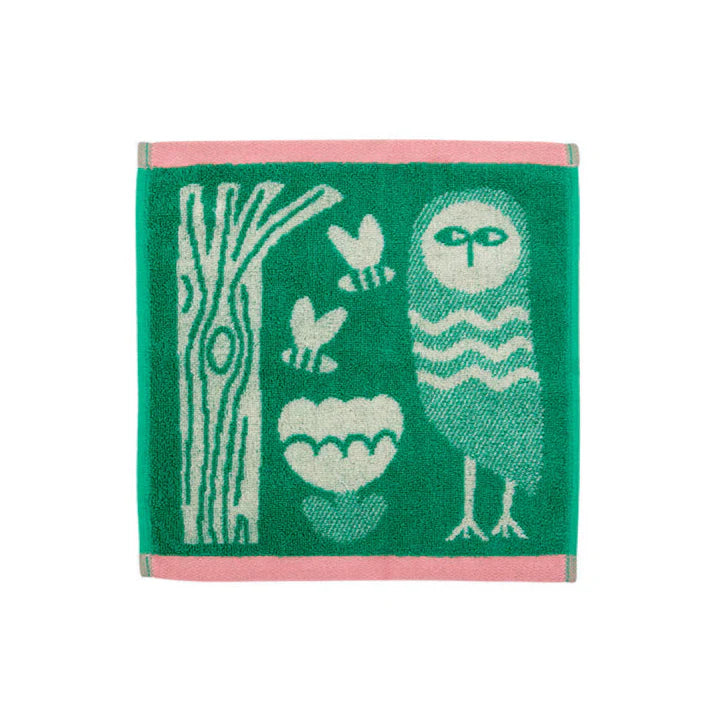 Green face cloth with an owl, a tree, bees and a flower