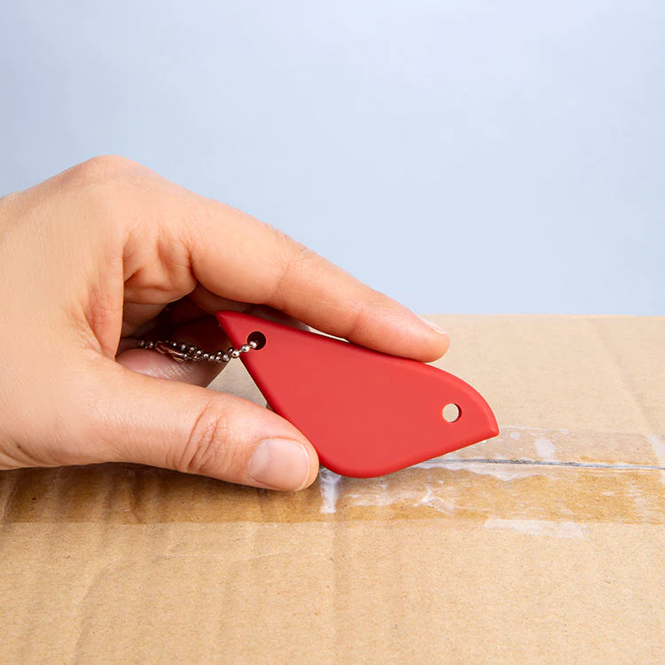 Hand using a red bird cutter to open a parcel
