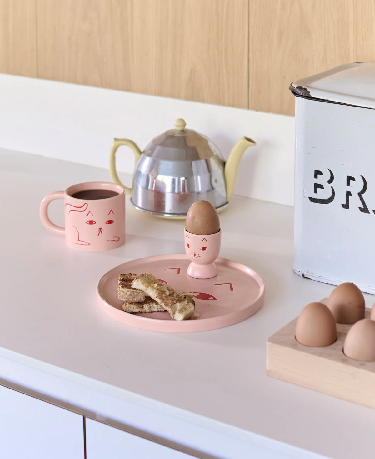Cat plate, mug and egg cup on a kitchen counter