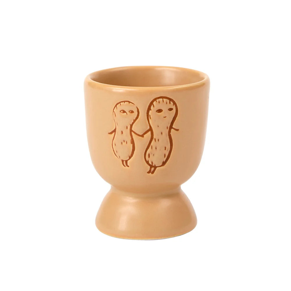 Donna Wilson egg cup in tan with two peanut characters holding hands