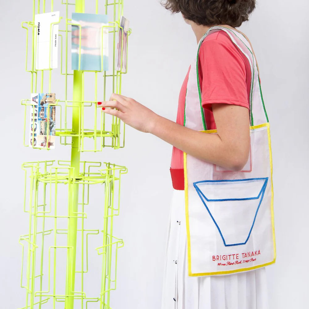 Woman carrying the Pop Pocket bag beside a postcard rack