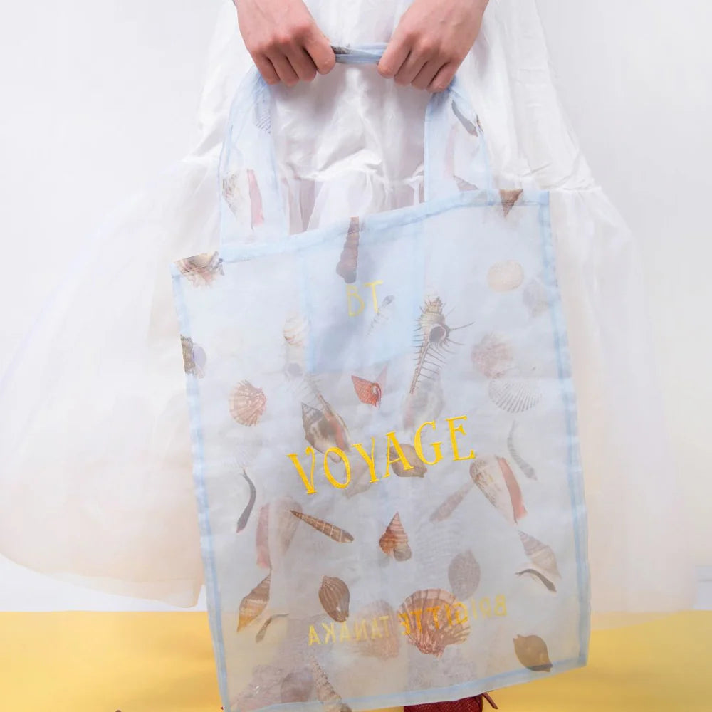 Hands holding the Shell Voyage organza bag