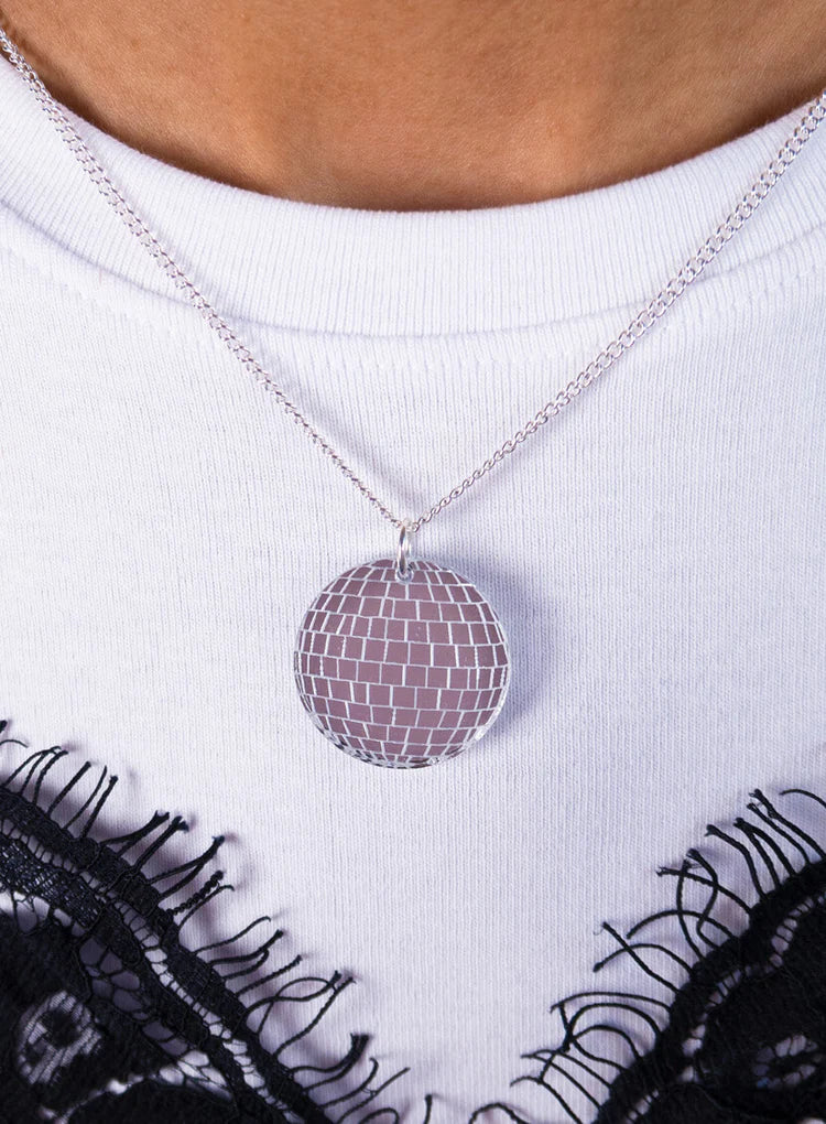 Disco ball pendant worn with a white top