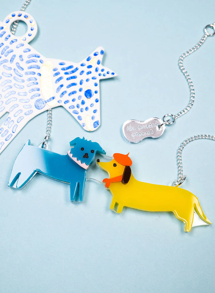Dog walk necklace on a blue patterned background