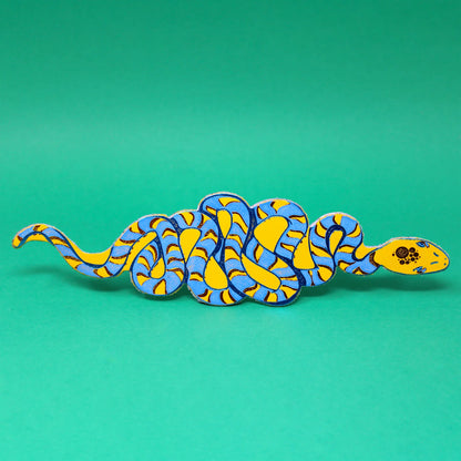 Yellow and blue coiled snake leather bookmark on a green background