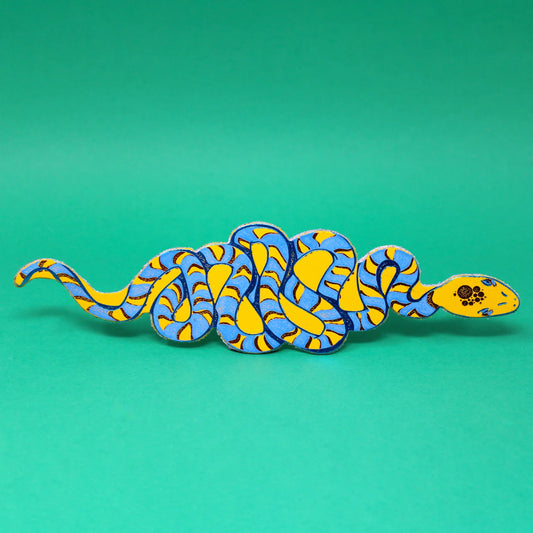 Yellow and blue coiled snake leather bookmark on a green background